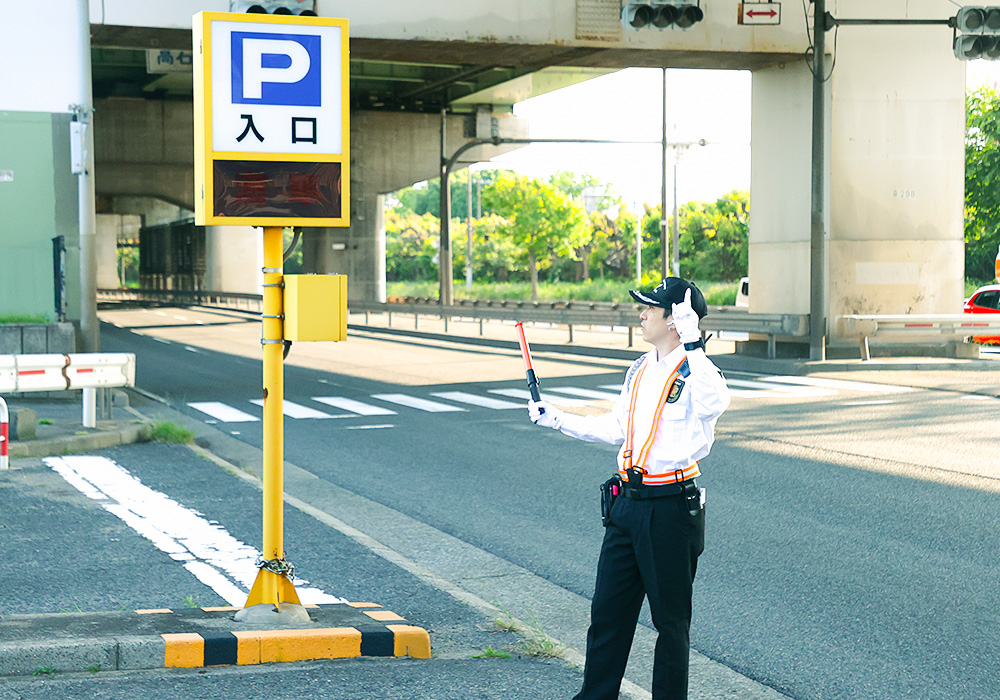 駐車場へ誘導するスタッフ